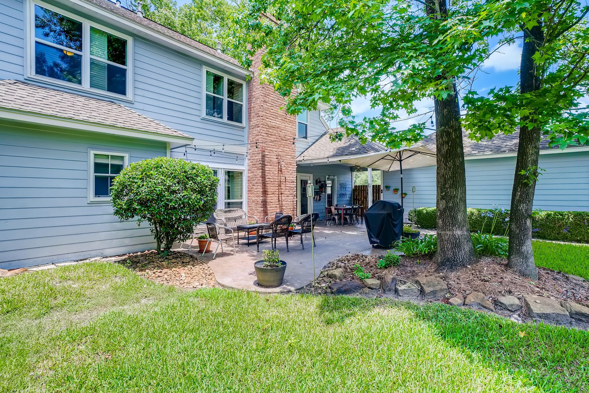 Beautiful residential backyard featuring a cozy patio and lush green surroundings.