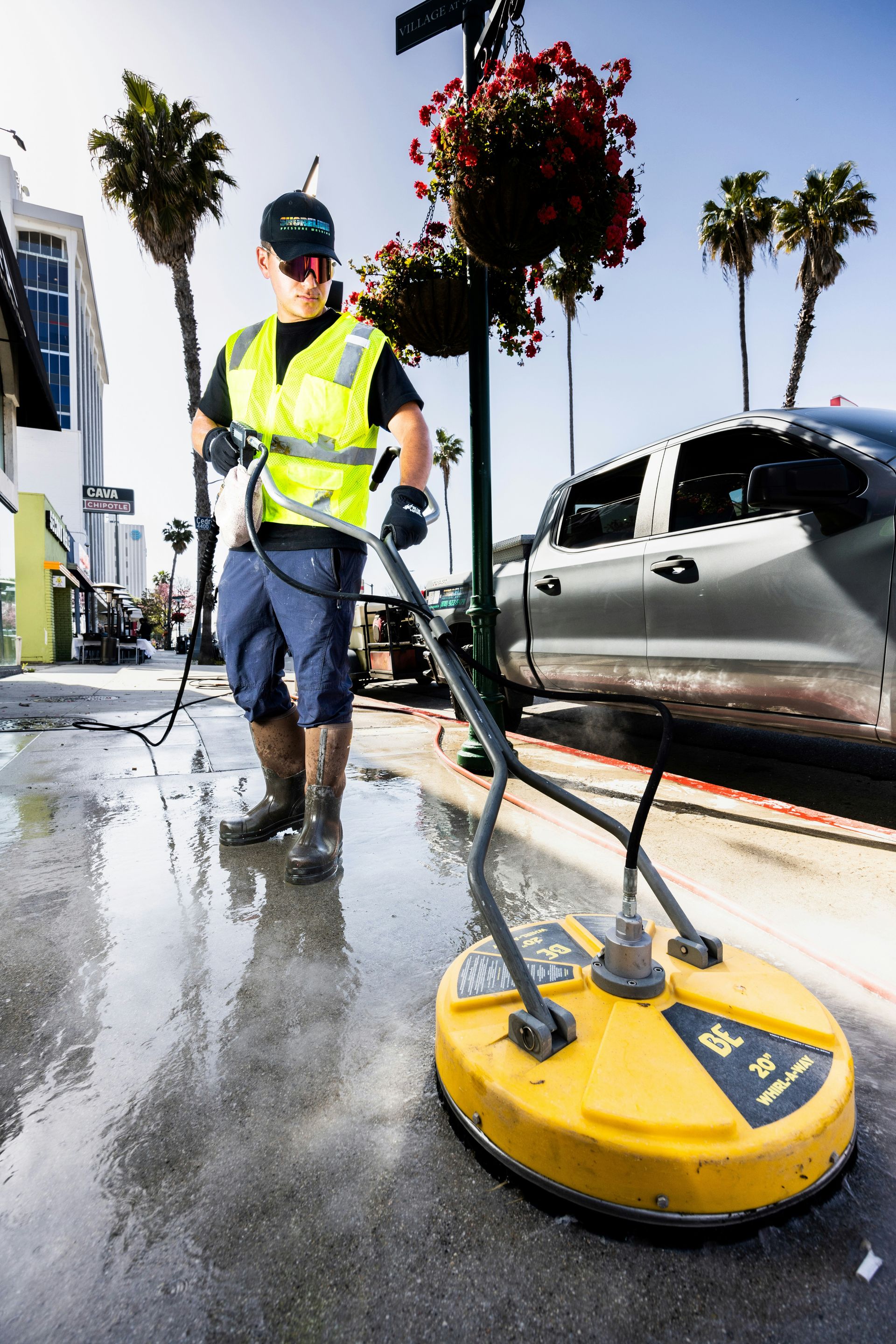 a man in a yellow vest is cleaning the street